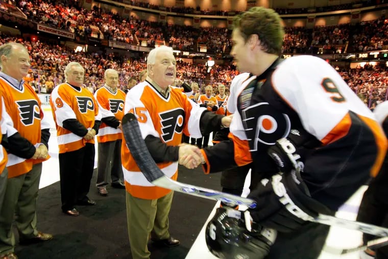 Terry Crisp, shaking hands with the Flyers' Scottie Upshall (eight) about 11 years ago, wants to meet the fan who got into the team's handshake line after the 1974 Stanley Cup clincher.