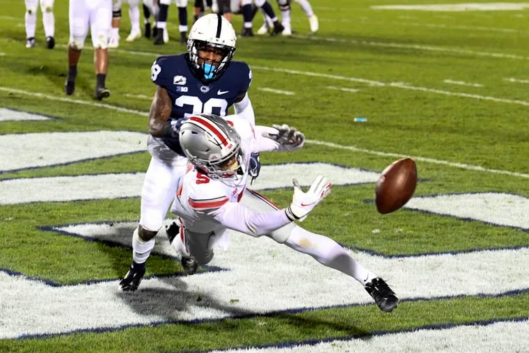 Ohio State wide receiver Garrett Wilson dives for a pass as Penn State safety Lamont Wade defends.