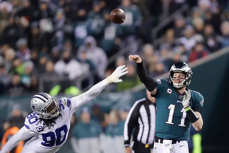 Carson Wentz (right) throwing a pass over Dallas Cowboys defensive end Demarcus Lawrence during the Eagles' 17-9 win Sunday at Lincoln Financial Field.