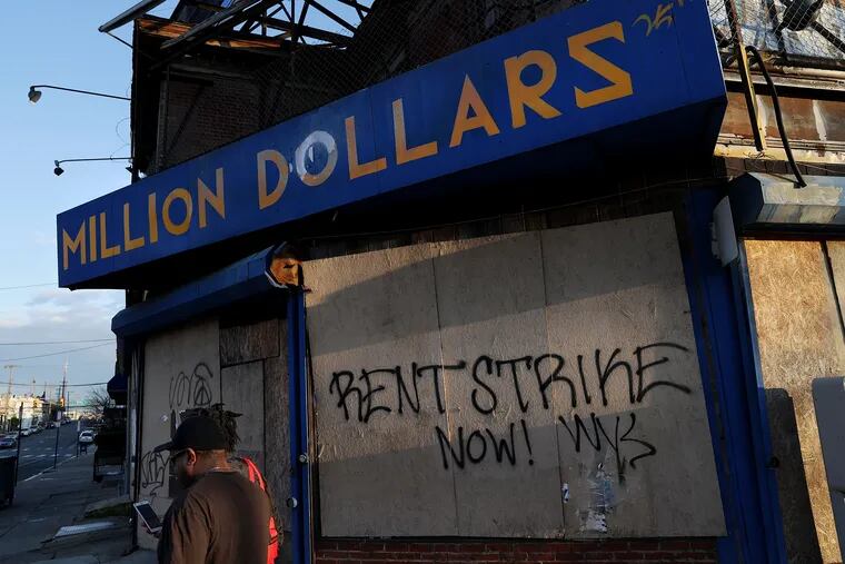 Graffiti calling for a rent strike is pictured on a corner store that closed long before the coronavirus pandemic in West Philadelphia, in April.
