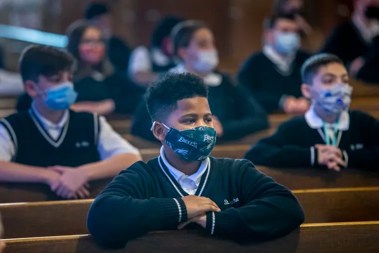 Students from St. Martha Parish School wear their masks and social distance during Ash Wednesday mass in February.