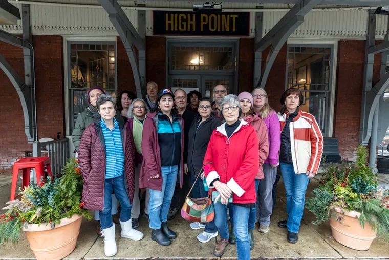 Members of the Save the Train Coalition pose for a group photo in front of the High Point Cafe at the Richard Allen Lane Regional Rail Station in Philadelphia, Pa., on Thursday, Jan. 25, 2024.