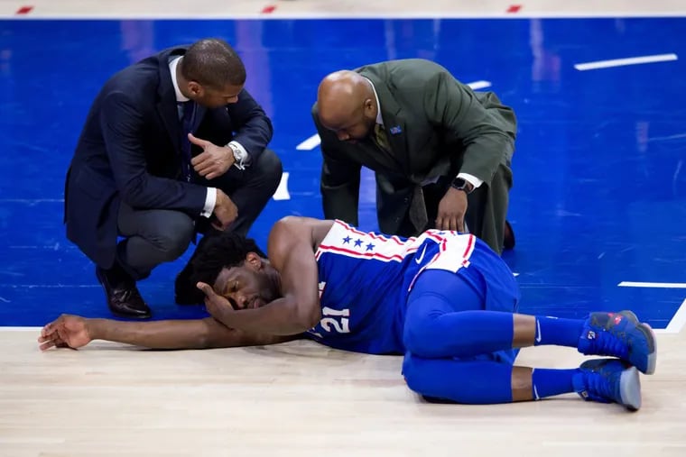 Philadelphia 76ers Center Joel Embiid (21) is attended to for an injury in the first half during the game between the New York Knicks and Philadelphia 76ers on March 28, 2018 at Wells Fargo Center in Philadelphia, PA.