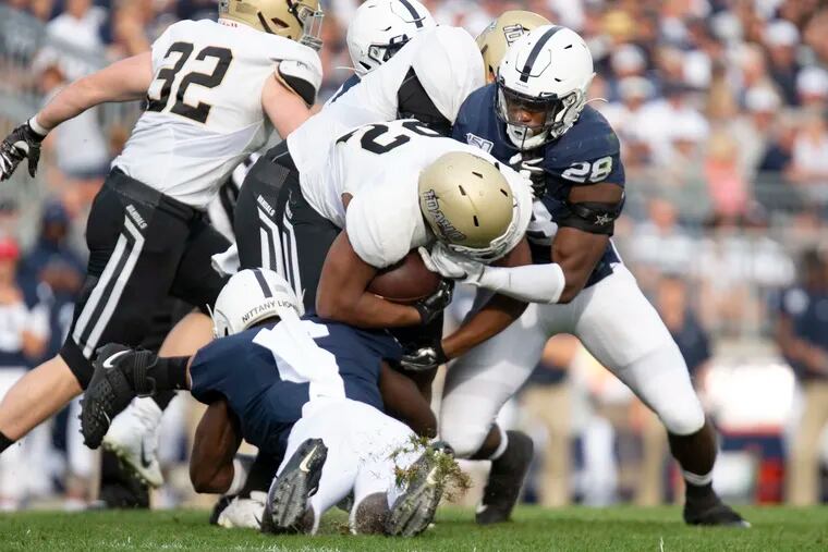 Defensive end Jayson Oweh (28), here helping make a tackle against Idaho, has been recognized by the Big Ten.