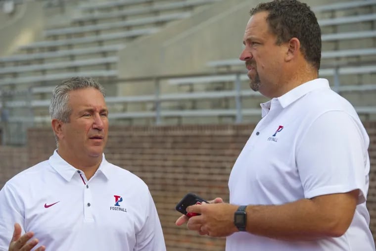 Penn coach Ray Priore (left) and offensive coordinator John Reagan talk during Penn Football’s media day at Franklin Field in West Philadelphia.