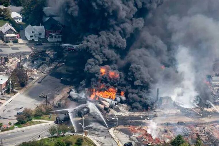 Smoke and flames rise from rail cars carrying crude oil that derailed and crashed in downtown Lac-Megantic, Quebec, on Saturday. (Paul Chiasson / Canadian Press)