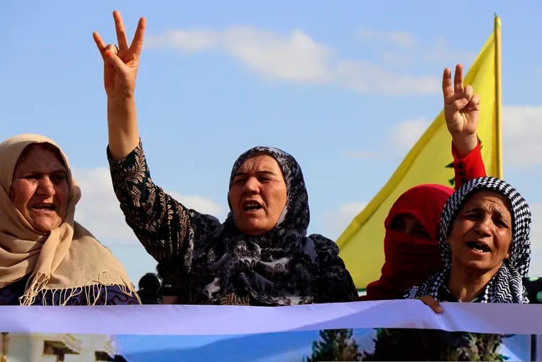 Kurdish women flash victory signs and shout slogans as they protest against possible Turkish military operation on their areas, at the Syrian-Turkish border, in Ras al-Ayn, Syria, Monday, Oct. 7, 2019. Syria's Kurds accused the U.S. of turning its back on its allies and risking gains made in the fight against the Islamic State group as American troops began pulling back on Monday from positions in northeastern Syria ahead of an expected Turkish assault.