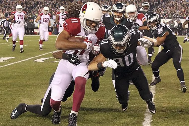 Larry Fitzgerald catches the football against the Eagles’ Ed Reynolds in the first-quarter on Sunday, December 20, 2015 in Philadelphia.  ( YONG KIM / Staff Photographer )