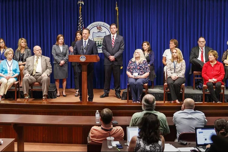 Pennsylvania Attorney General Josh Shapiro, center, speaks on the findings of the Grand Jury Report on Child Sexual Abuse in six Catholic Dioceses in Pennsylvania at the State Capital, with 16 victims or family members of victims of sexual abuse by Catholic priests, seated on stage with him, on August 14, 2018. (Michael Bryant/Philadelphia Inquirer/TNS)
