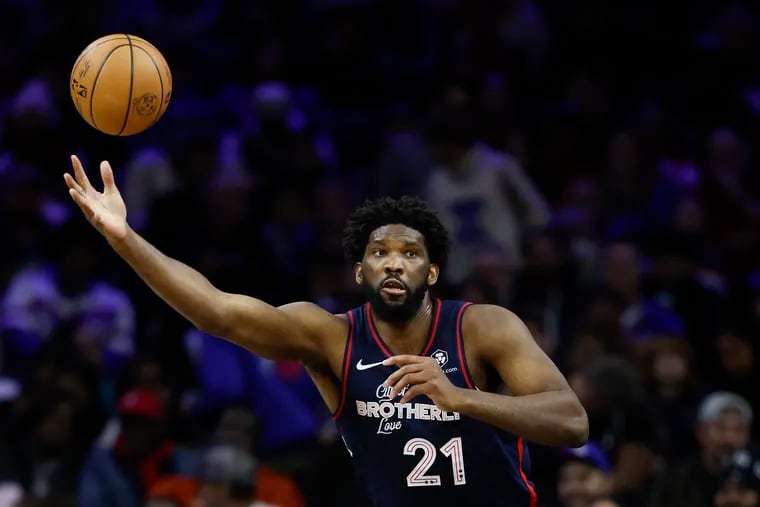 Sixers center Joel Embiid reaches for the ball during his 70-point outing against the Spurs on Monday.