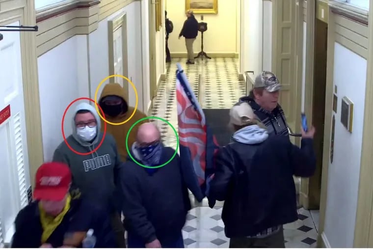 Security camera footage from the U.S. Capitol shows Nicholas Krauss (in green Puma hoodie), Russell Dodge (in gold hoodie), and David Krauss (wearing a bandana over his face) among the rioters who stormed the building during the Jan. 6, 2021, attack on Congress.