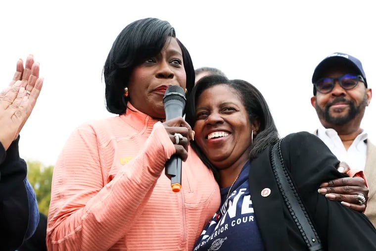 Mayor-elect Cherelle Parker (left) hugs Judge Timika Lane, who was elected to the Pennsylvania Superior Court, during a get-out-the-vote motorcade Parker hosted in West Philadelphia last Saturday.