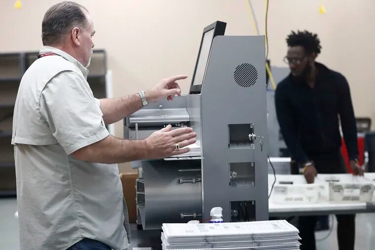 Workers load ballots into machines at the Broward County Supervisor of Elections office during a recount on Sunday, Nov. 11, 2018, in Lauderhill, Fla. (AP Photo/Brynn Anderson)
