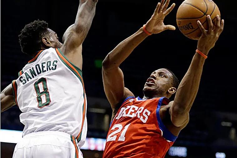 76ers forward Thaddeus Young shoots against the Bucks' Larry Sanders during the first half. (Jeffrey Phelps/AP)