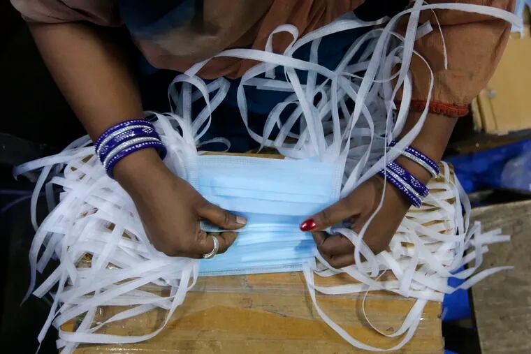 An Indian laborer works at a surgical mask production unit in Ahmadabad, India. India has banned the export of all varieties of respiratory masks in view of a coronavirus outbreak that began in China, which has infected more than 14,550 people globally.