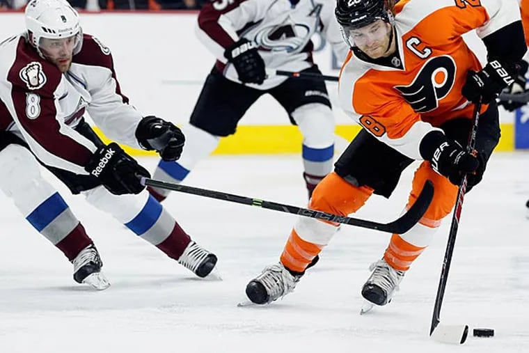 Philadelphia Flyers' Claude Giroux (28), right, maneuvers the puck followed by Colorado Avalanche's Jan Hejda (8), left, during the second period of their NHL hockey game, Saturday, Nov. 8, 2014, in Philadelphia. (Tom Mihalek/AP)