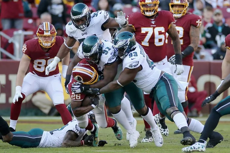 Eagles defensive tackles Fletcher Cox (91) and Tim Jernigan (93) wrap up Redskins running back Adrian Peterson (26) in the Eagles win at Washington last season.