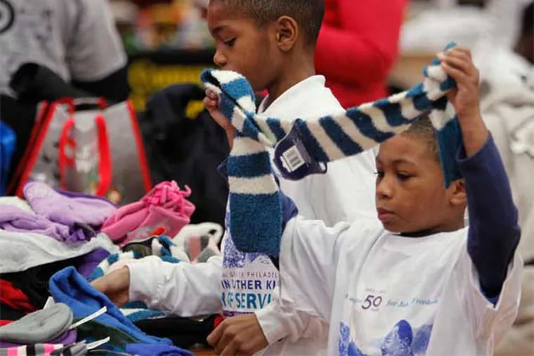 Jeremiah Luff , 6, sorts scarves and gloves donated by the Liberty Council Pack and Troop 125, a Boy Scout troop based in Olney, at Girard College's Day of Service celebration. (Alejandro A. Alvarez / Staff Photographer)