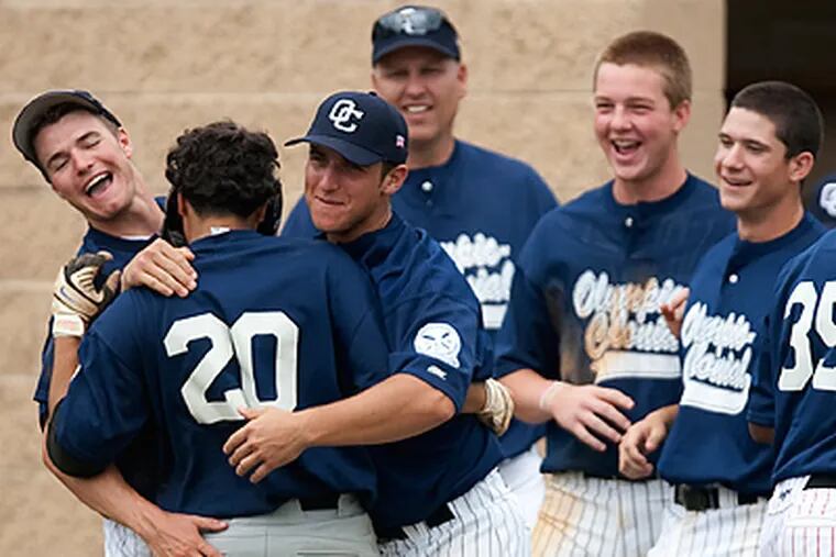 Wilson Ulloa, 20, a senior from CCT playing for Olympic Colonial is mobbed by teammates after scoring the winning run in the 9th inning. (Ed Hille / Staff Photographer)