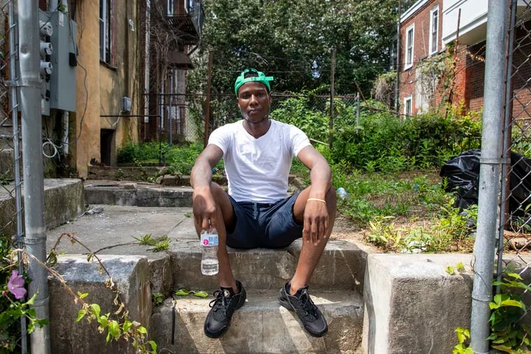 Jamar Nesmith, 27, of North Philadelphia, sits outside next to the home where the shootings took place. "What's important to me is to have these kids to play on the streets again," Nesmith said. "Hearing music on the block instead of gunshots."
