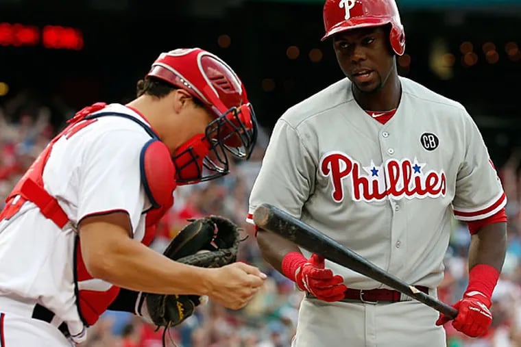 Nationals catcher Jose Lobaton pumps his fist as Philadelphia Phillies' John Mayberry Jr., right, steps away after he made the last out of the ninth inning of a baseball game at Nationals Park Thursday, June 5, 2014, in Washington. The Nationals won 4-2. (Alex Brandon/AP)