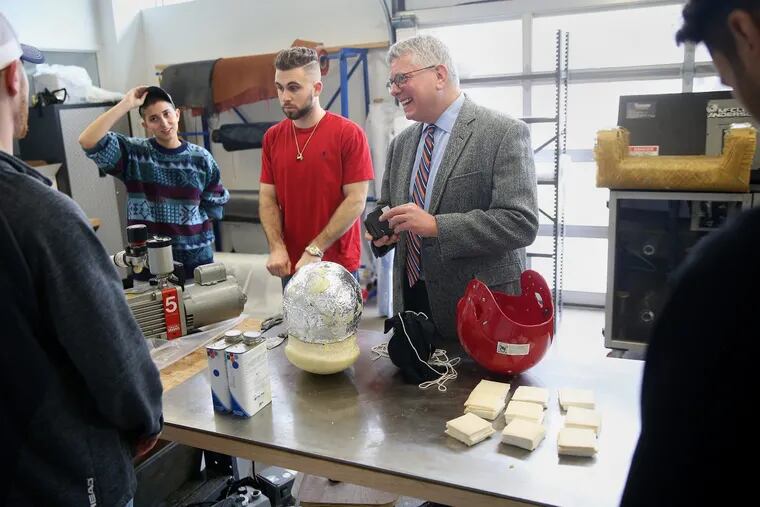 Stanton Miller, right, a surgeon and executive director of the Jefferson Center for Injury Research and Prevention, works with engineering students, including Olivia Mermigos, left, and Andrew Gabriele, about their helmet design project on the East Falls campus. TIM TAI / Staff Photographer