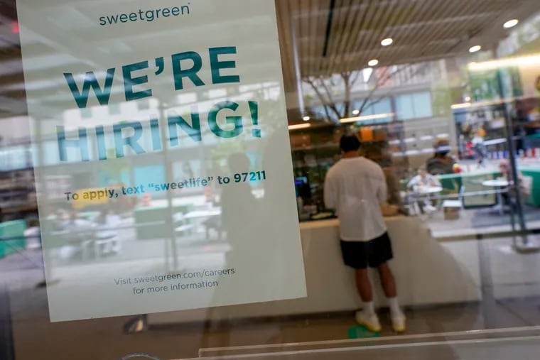 A sign announcing the ability to hire hangs in the window of a restaurant in the Greenwich Village neighborhood of New York City.