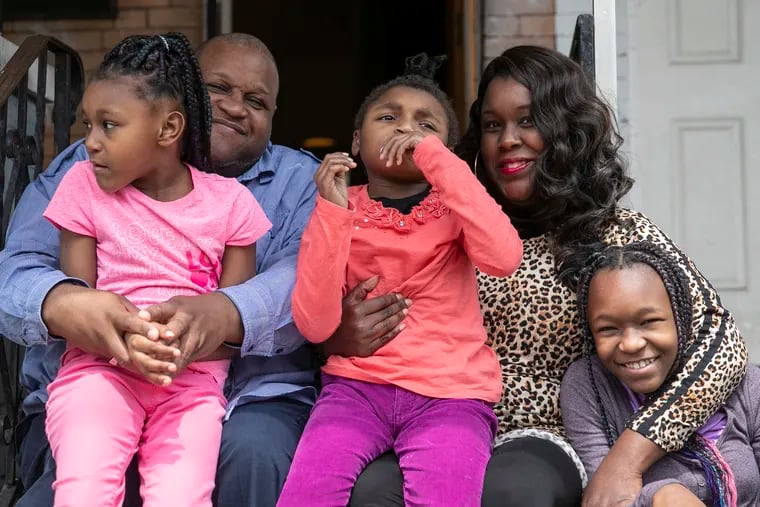 Syrita and Aaron Powers pose for a portrait with their daughters, Logan, left, Georgia, center, and Madison outside their home in West Philadelphia on Friday. The couple is unsure how they will be able to educate their children, who have different disabilities, and meet their varying needs while schools remain closed.