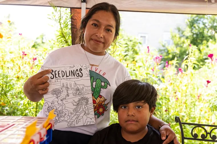 Erendira Zamacona, 34, del sur de Filadelfia, y su hijo, César Tapia Zamacona, 8, posan con el libro para colorear Seedlings. El editorial es parte de una serie de esfuerzos que están desarrollando artistas y miembros de la comunidad para encontrar soluciones al calor extremo en Filadelfia.