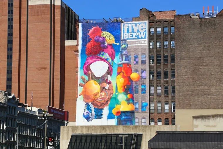 An unfinished eight-story mural on the corner of Eighth and Market Streets. The mural, designed by Meg Saligman Studios, features a large logo for Five Below in the upper right corner.