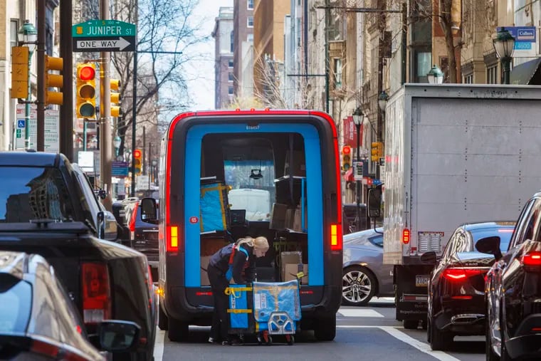 An Amazon delivery person takes packages out of her truck on Chestnut Street in Center City. Some Philadelphia consumers say they can't break their Amazon shopping habit, despite having ethical concerns with the company and its owner, billionaire Jeff Bezos.
