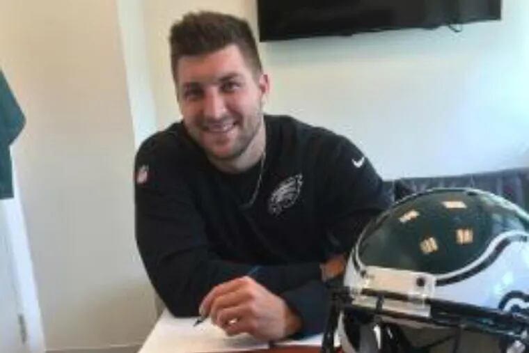 Tim Tebow signs his contract with the Eagles. (Photo courtesy of the Philadelphia Eagles)
