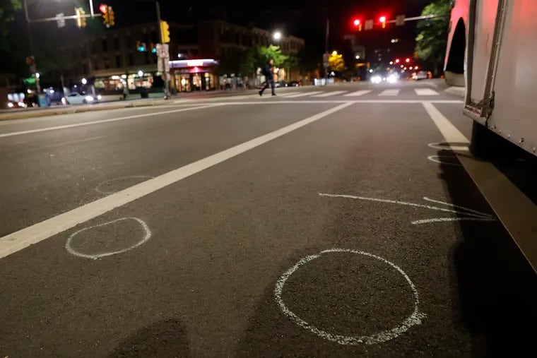 Chalk circles mark where the evidence was found on southbound 38th Street at Spruce Street in Philadelphia on Sunday. At that location around 4 a.m. on Saturday, John Albert Laylo, an attorney from the Philippines, was killed when a person opened fire on the Uber he was riding in with his mother.