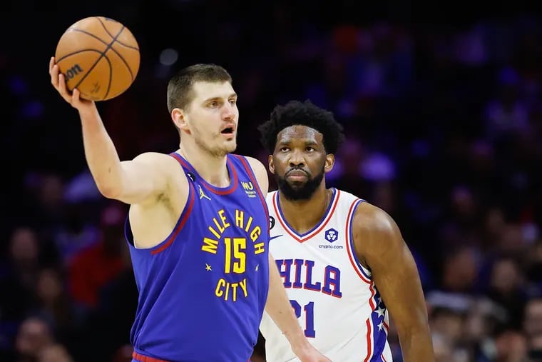 Sixers center Joel Embiid watches Denver Nuggets center Nikola Jokic catches the basketball on Saturday, January 28, 2023 in Philadelphia.