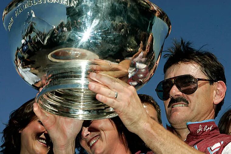 Driver John Campbell, right, holds up the Hambletonian trophy Saturday, Aug. 5, 2006 at Meadowlands Racetrack.