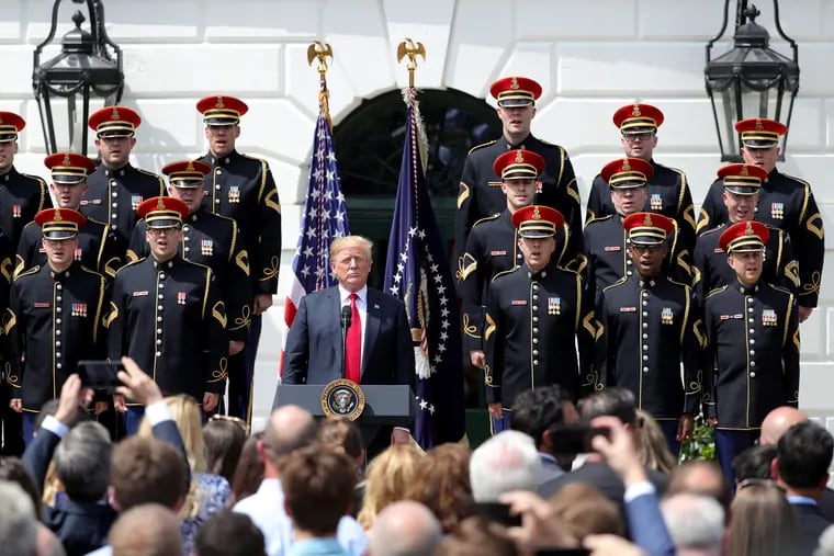 President Trump listens during the singing of "God Bless America" during Tuesday's White House celebration sans the Eagles. 