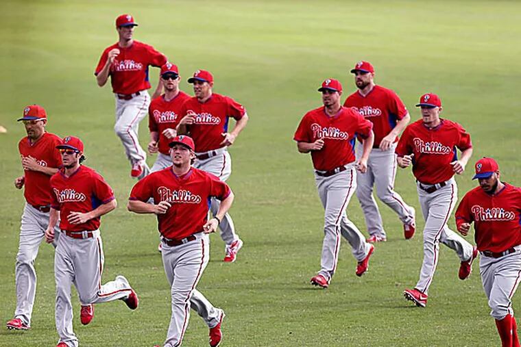 Phillies players run in the outfield. (Charlie Neibergall/AP)