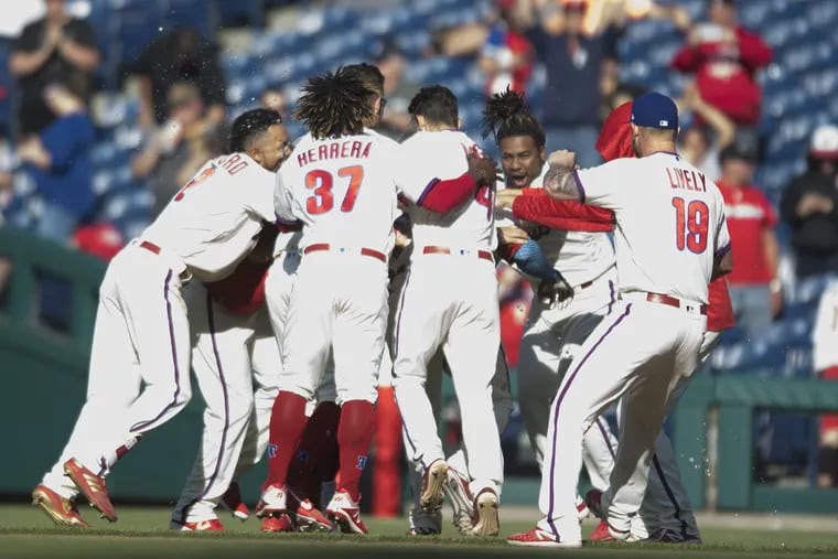 Phillies players mob Aaron Altherr (23) after his walk-off hit against the Pirates.