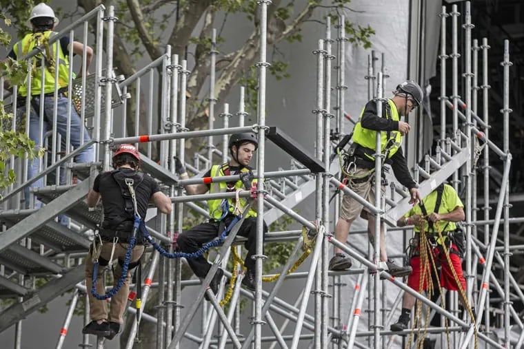 Looking like kids on a jungle gym, workers for IATSE Local 8 stage hands spend Sunday taking apart the scaffolding that made up the southern stairs into the NFL draft theater.  Hundreds of hard hats are dismantling the mammoth stage, which obscures the Art Museum, and could take days to deconstruct.