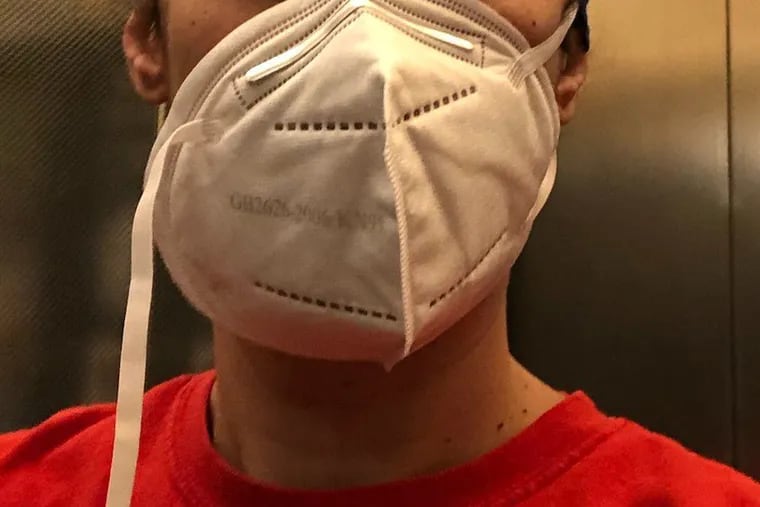 A KN95 mask issued by Temple University Hospital with a broken strap.