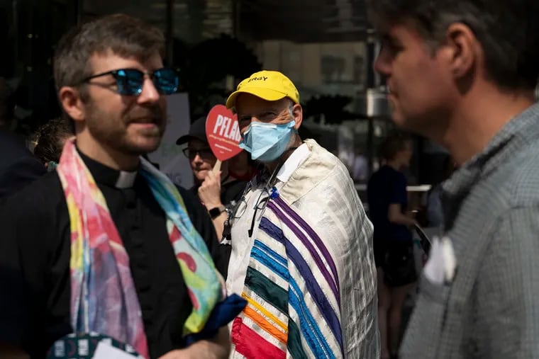 A protester wearing a Jewish prayer shawl in rainbow hues joins demonstrators gathered outside the Moms for Liberty meeting in Philadelphia on Friday.