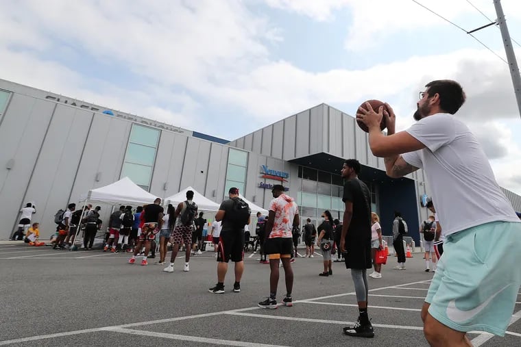 Steve Basile (right), of Delaware County, practices his moves while waiting in line outside the 76ers Fieldhouse in Wilmington.