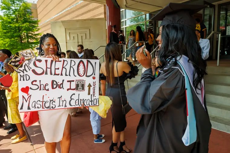Danita Sherrod, left, mother of Najah Sherrod. (right) displays a sign for her daughter outside the Liacouras Center. Najah graduated with a master's in education.