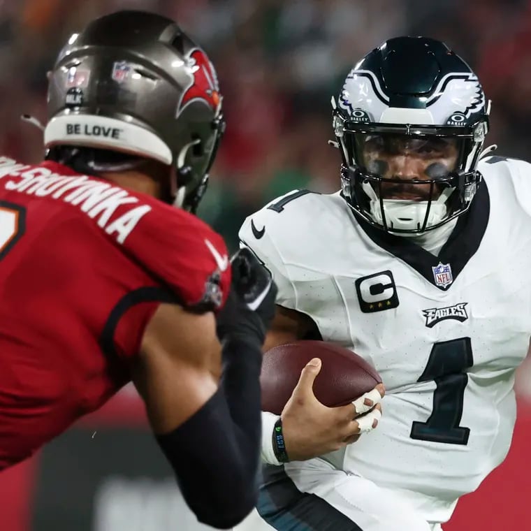 Eagles quarterback Jalen Hurts keeps the ball on a run with Tampa Bay Buccaneers linebacker Joe Tryon-Shoyinka giving chase in the wild-card round of the NFL playoffs at Raymond James Stadium in Tampa , Fla. on Monday, Jan. 15, 2024.