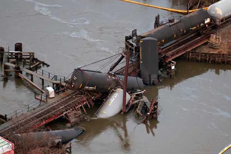 Derailed freight train cars lay in water in Paulsboro, N.J., on Friday, Nov. 30, 2012. The cars, which were carrying hazardous materials, toppled from a bridge and into a creek. (AP Photo/Cliff Owen)