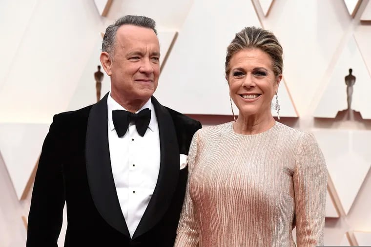 Tom Hanks and Rita Wilson arrive at the Oscars at the Dolby Theatre in Los Angeles. The couple have tested positive for the coronavirus, the actor said in a statement Wednesday.