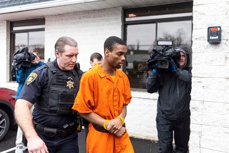 Andre Gordon Jr. is escorted by officers as he arrives for his arraignment at the Magisterial District Courthouse in Fallsington on Wednesday.