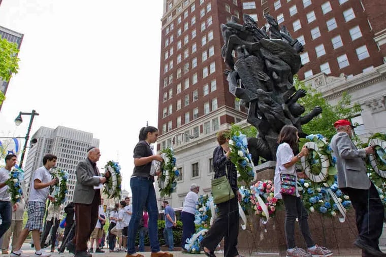 At the foot of "Monument to Six Million Jewish Martyrs" on the Parkway at 16th Street, participants bear wreaths in memory of those who died in the Holocaust