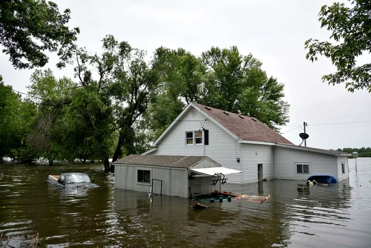 In this Monday, June 3, 2019 photo, a house and pickup truck are submerged in floodwaters as the Missouri River continues to rise in McBaine, Mo. (Kate Seaman/Missourian via AP)