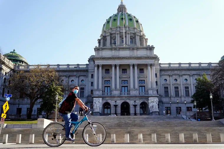A cyclist rides past the Pennsylvania Capitol in Harrisburg on March 22, 2021.